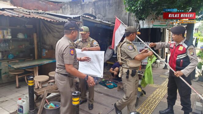 
Petugas Gabungan Tertibkan Atribut Ormas di Kecamatan Matraman Jakarta Timur